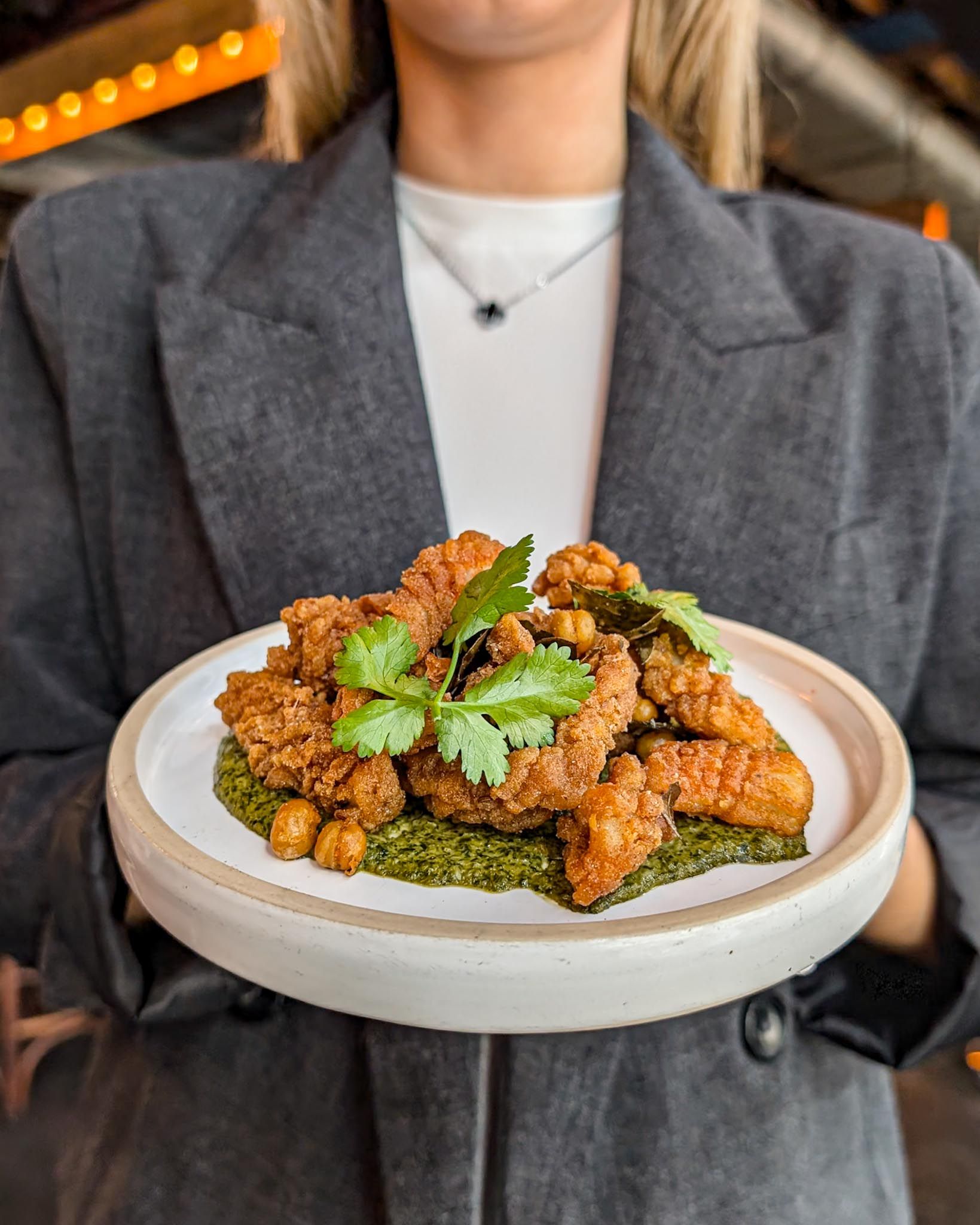 Waitress serving a crispy fried squid dish at The Bar in Farringdon.