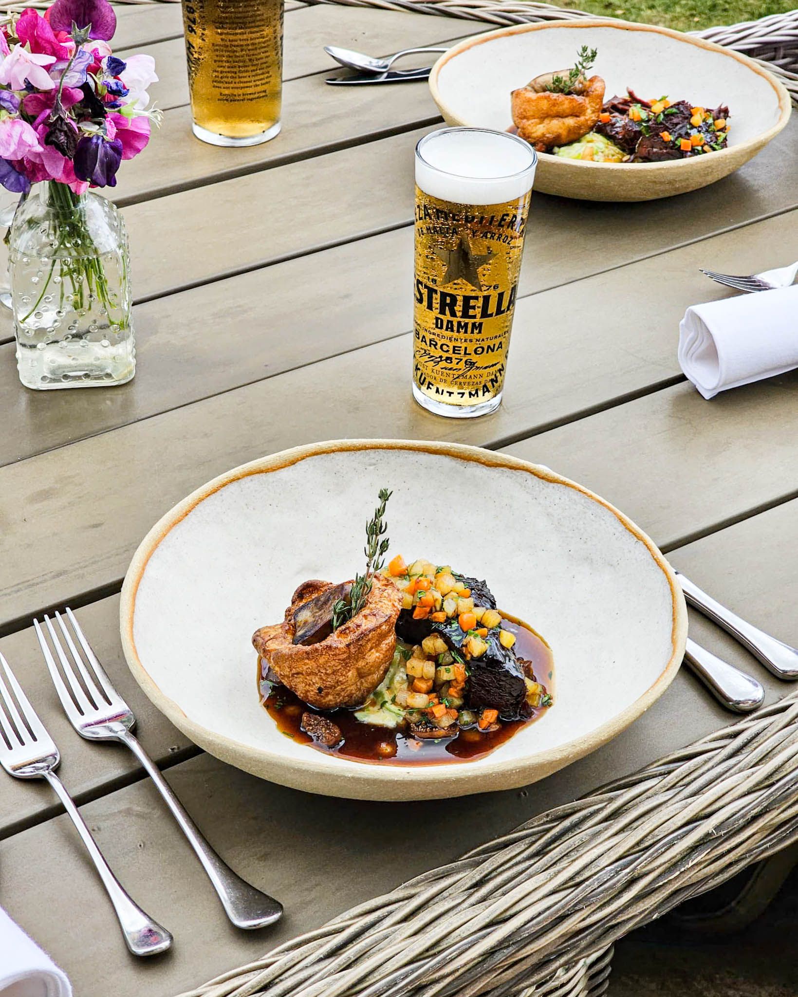 A stunning dish of food created by Michelin-starred chef Andrew Pern, shown alongside a frothy pint of Estrella lager at our special event.