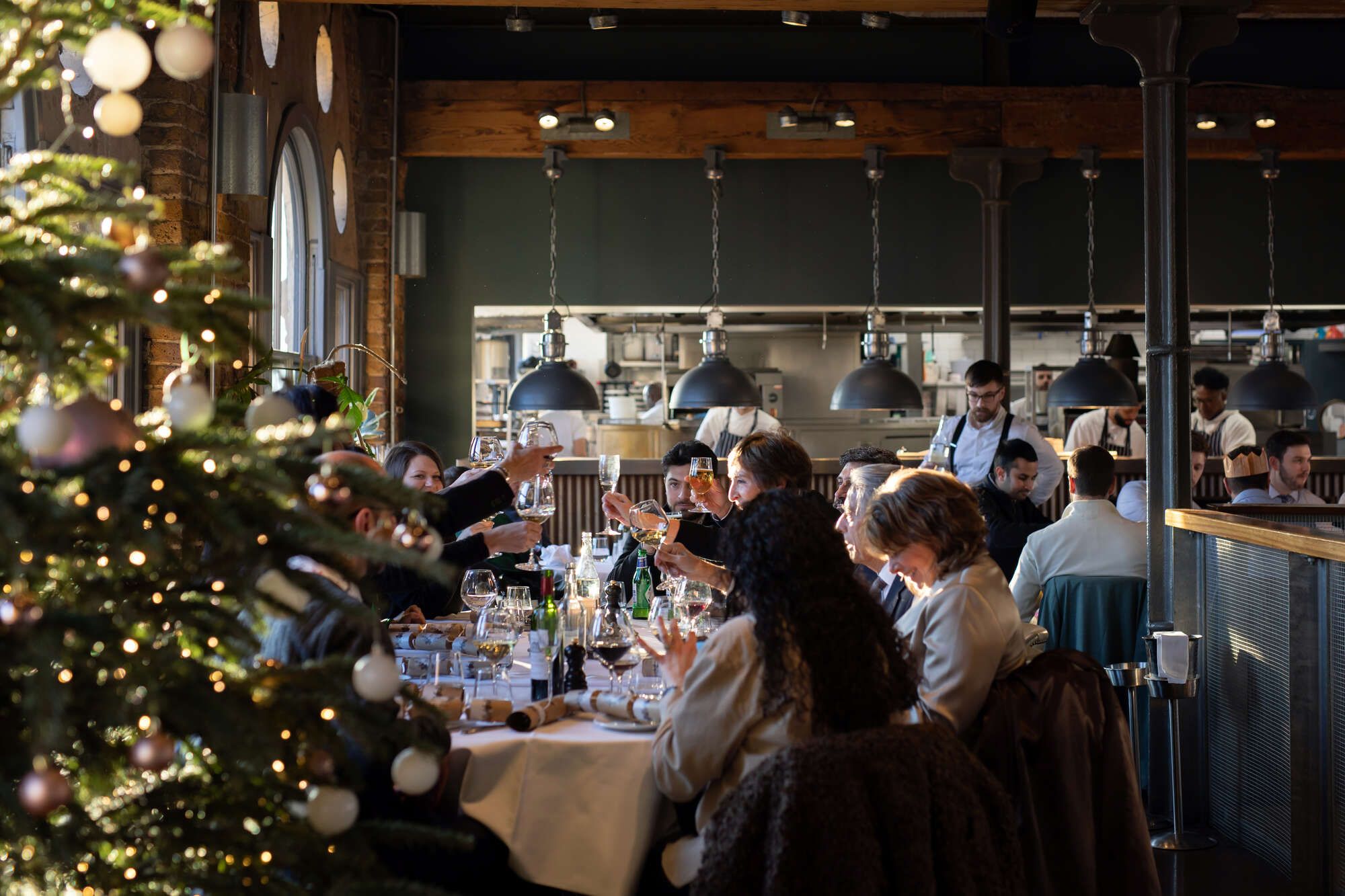 A group of work colleagues toast each other at their christmas dinner in a farringdon restaurant