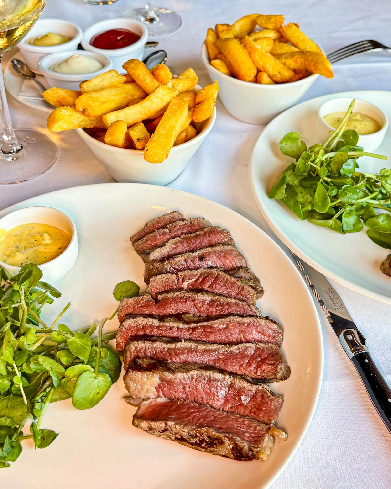 Plated 8oz Flat Iron steak lunch special, served with golden triple-cut chips, available at The Grill Clerkenwell.