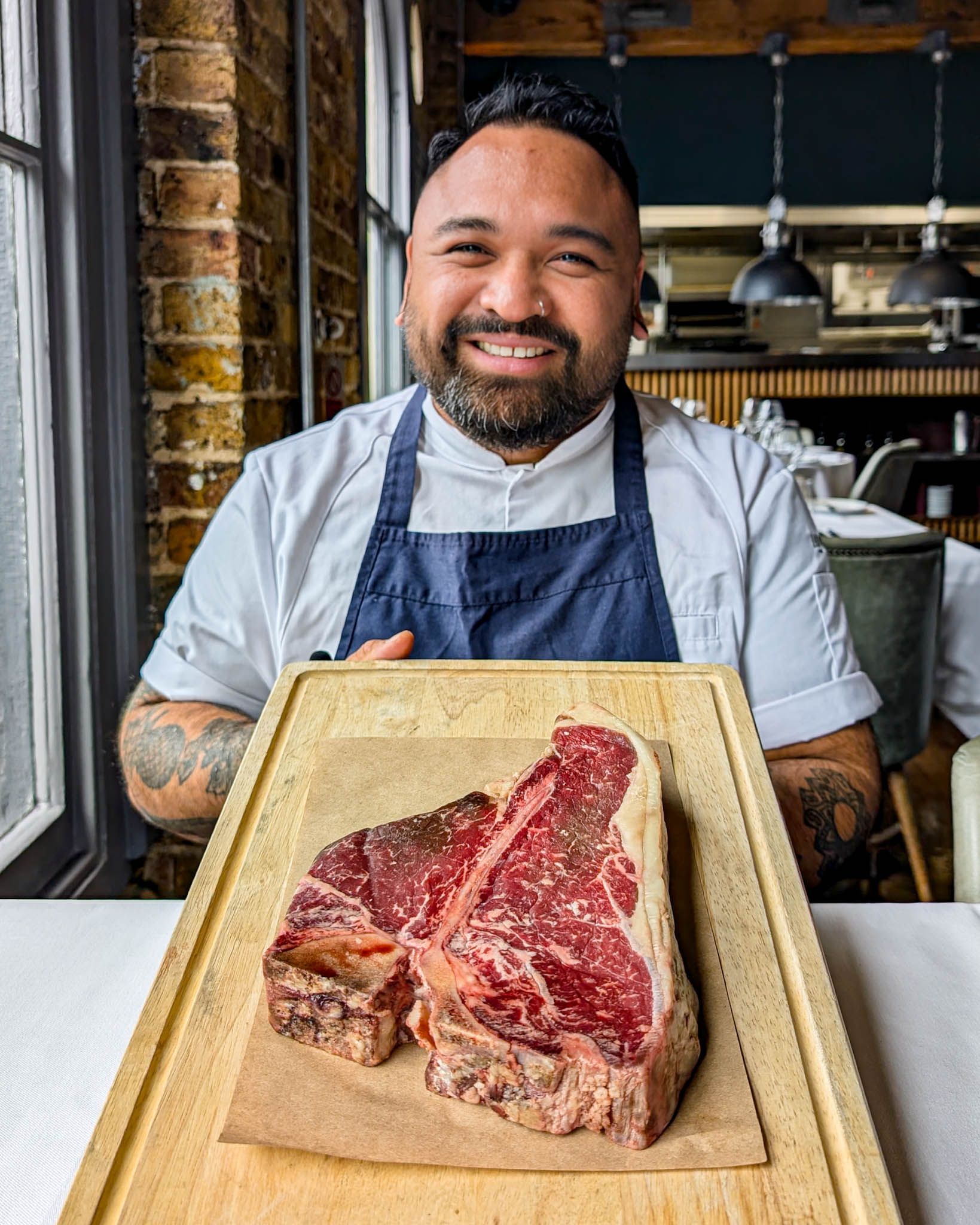 Head Chef Tim holding a large, marbled 36oz T-Bone cut of beef, showcasing the quality of the steaks at Smiths of Smithfield.
