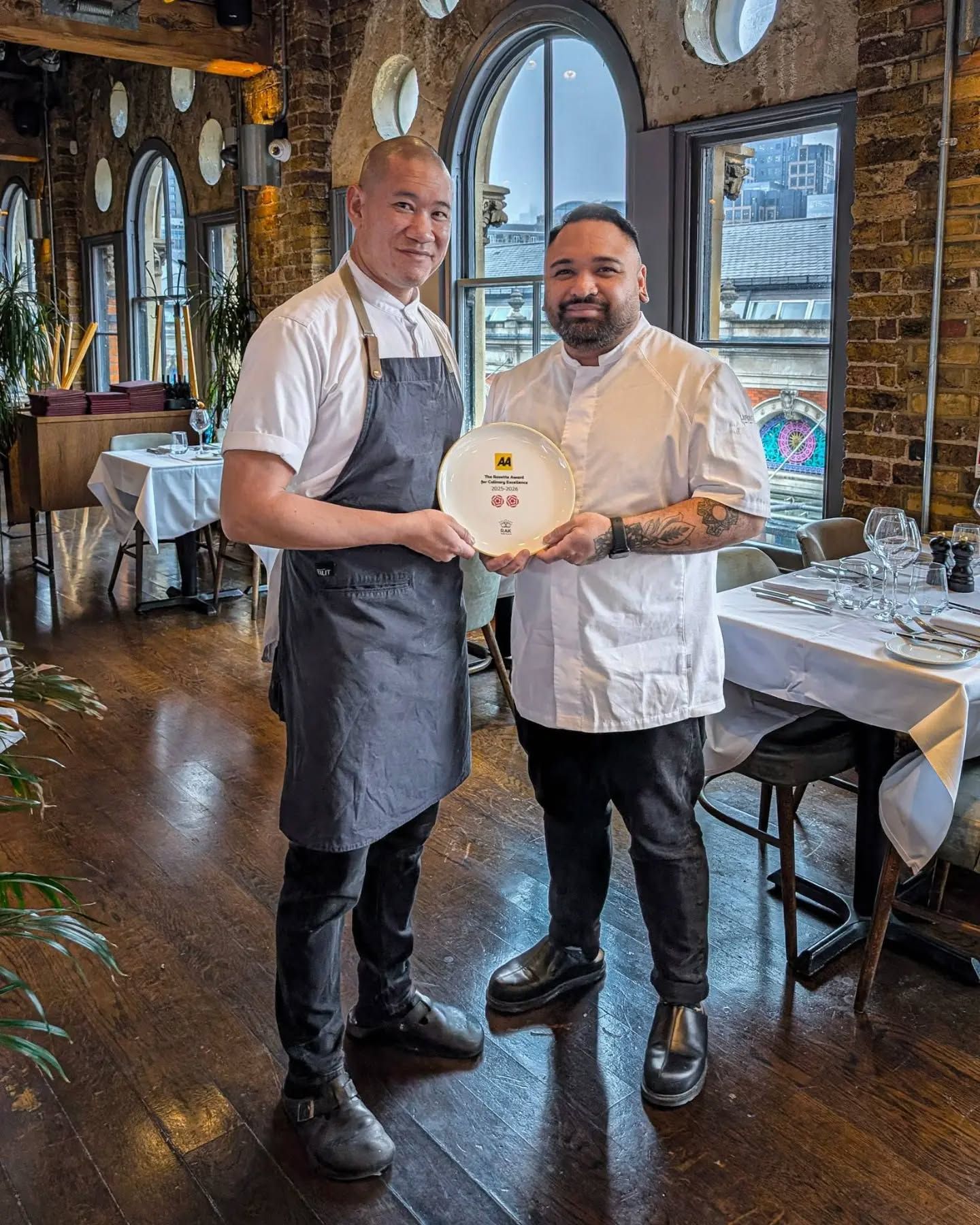 Head Chef Tim and Head of Pastry Wyman holding the two AA rosette plate awarded for being a top quality steak restaurant in smithfield market near farringdon and clerkenwell