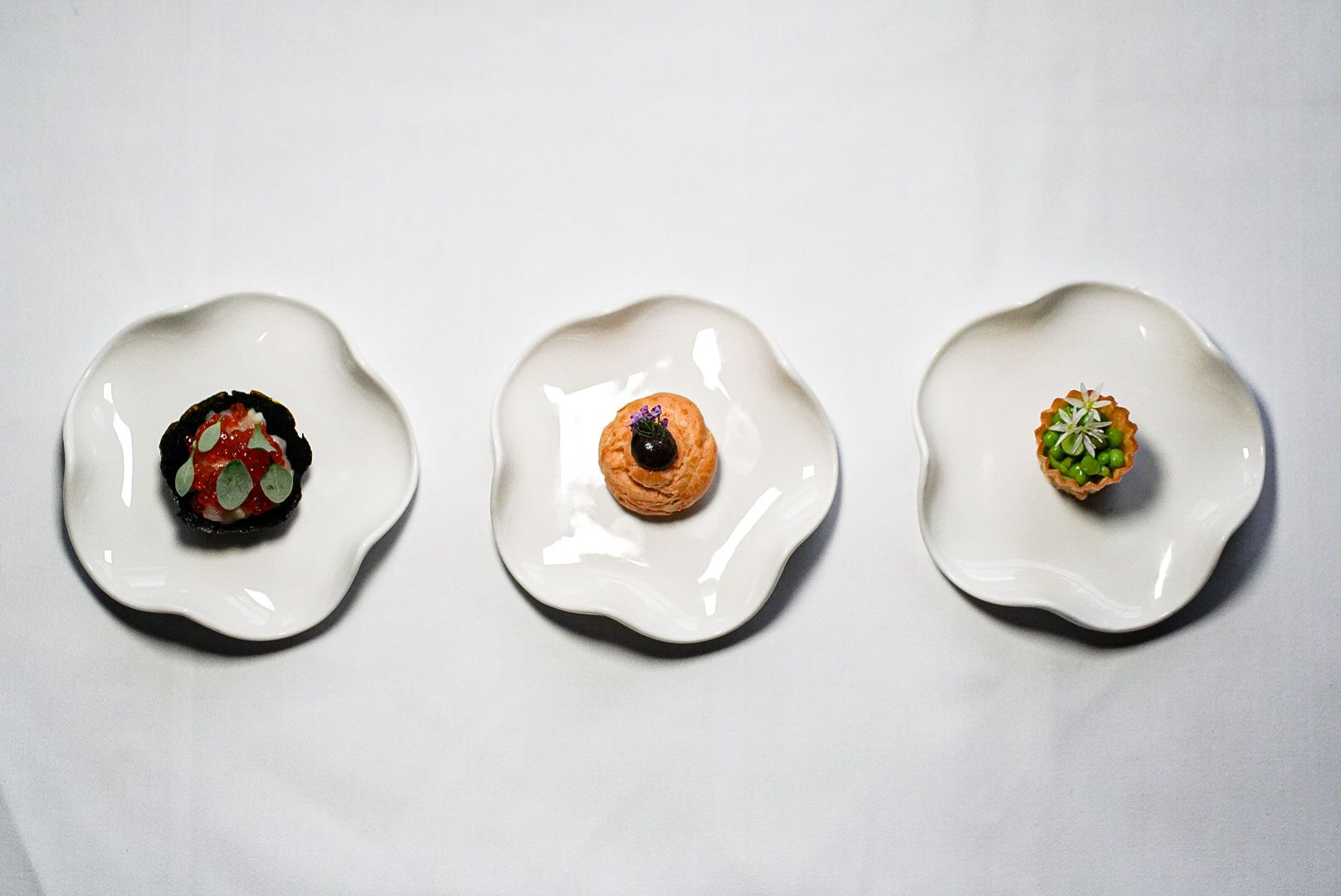 A selection of seasonal canapés from the tasting menu, including cheese and onion gougère with pickled walnut and Orkney scallop with yuzu and wasabi.