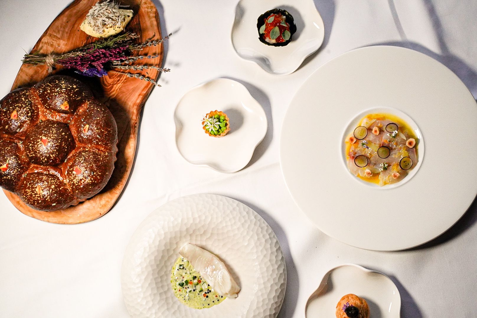 A top-down hero view of the complete 7-course fine dining tasting menu at The Grill, featuring seasonal British dishes and Scotch beef.
